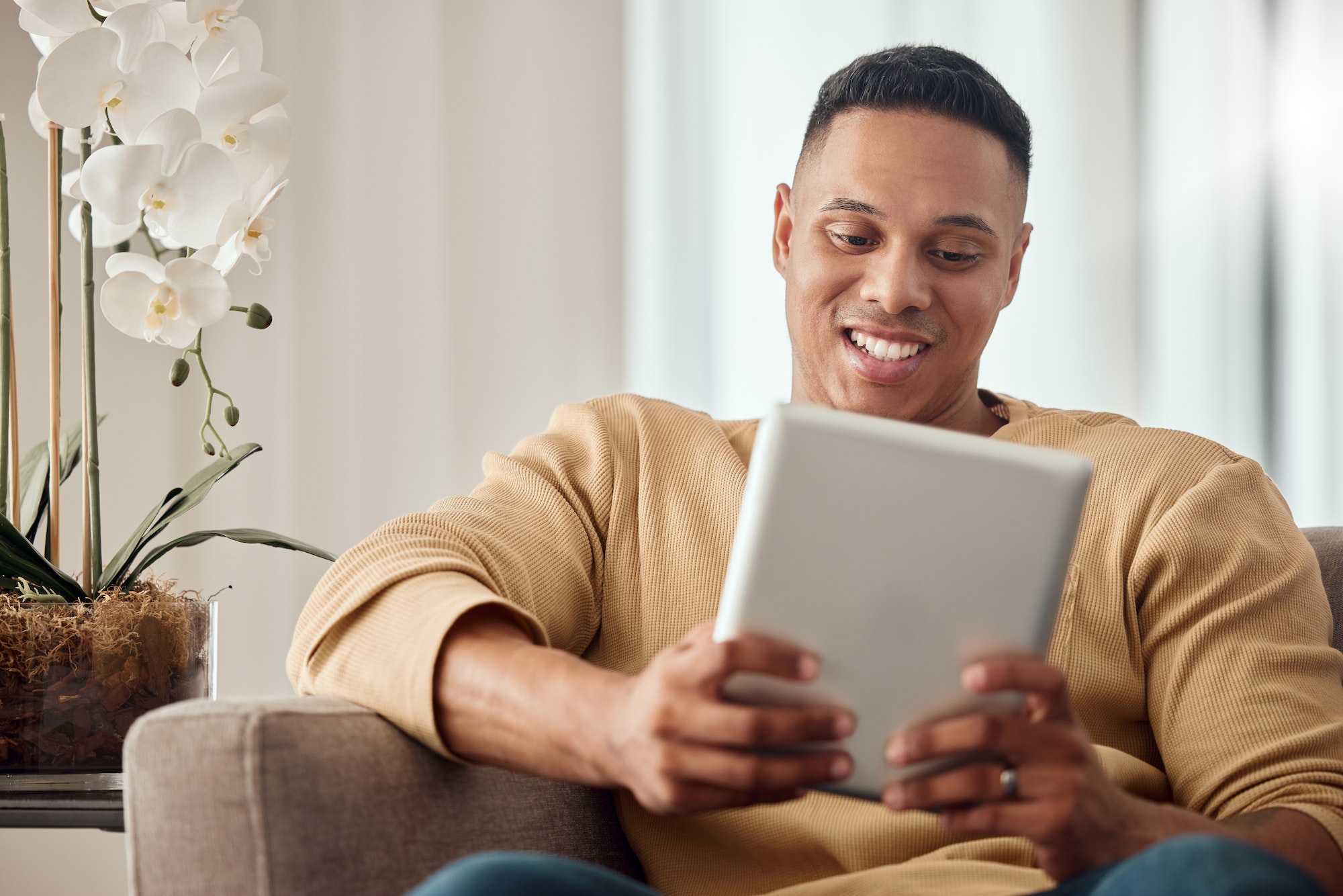 Tablet, sofa and black man with website information, video subscription service or surfing social m